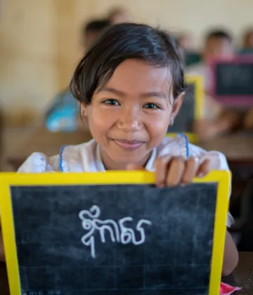 A girl shows her khmer writing on a personal chalk board at Kampong Thmar Primary School, Kang Sao village, Santok district, Kampong Thom commune, Kampong Thom province on July 4, 2018.