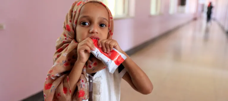 A small girl eats plumpy nut whilebeing treated for malnutirtion at a hostpial Sa'ana on November 2, 2018