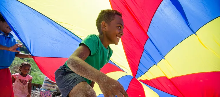 Een jongen speelt in een kindvriendelijke ruimte van UNICEF op het eiland, Republiek Fiji, na de verwoestingen door de tropische cycloon Yasa. 