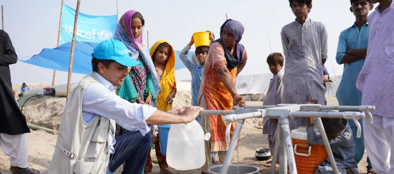 Ihsan Ullah Khan, UNICEF Wash Officer, vult een bus met water aan de pomp die UNICEF installeerde in een kamp voor mensen die getroffen werden door de overstromingen in Sindh, Pakistan. © UNICEF/UN0707019/Butt
