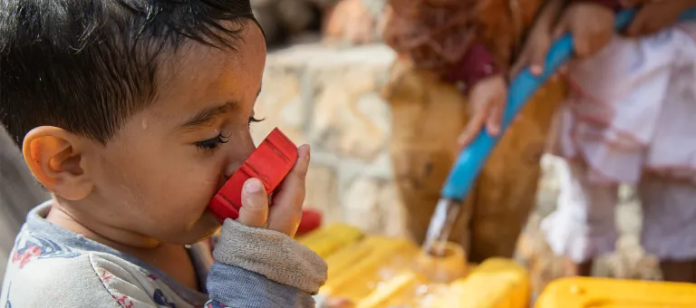 Rayan Abdo, 2,5 jaar oud, drinkt met volle teugen van het water dat door UNICEF wordt aangevoerd in Taizz, Jemen. 